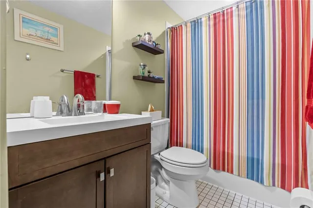 a bathroom with a sink a toilet and shower curtain
