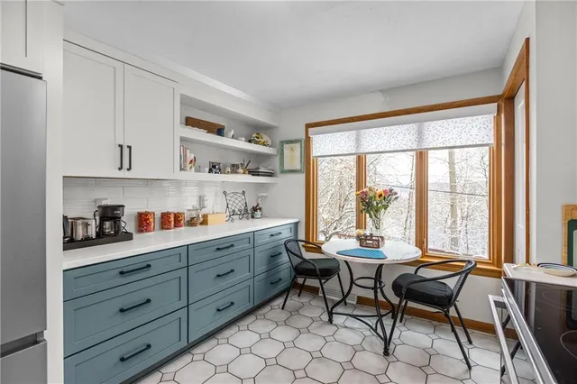 a reading room with furniture a large window and a wooden floor