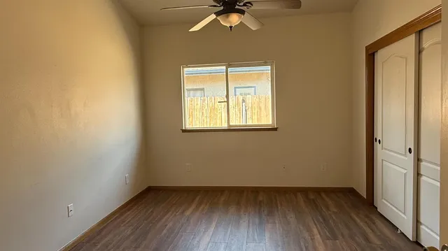 an empty room with a window and wooden floor