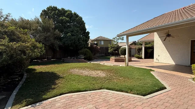 a view of a house with backyard and trees
