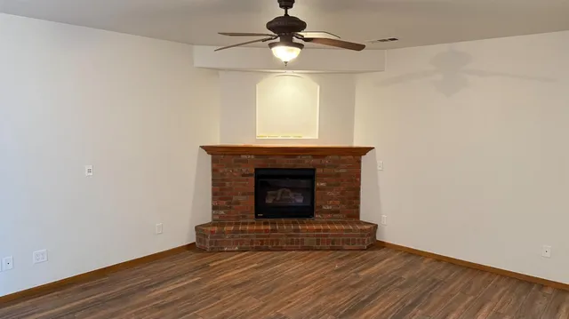 a room with a fireplace and a ceiling fan