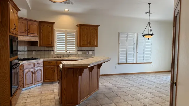 a kitchen with stainless steel appliances granite countertop a sink and a stove