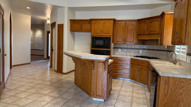 a kitchen with stainless steel appliances granite countertop a refrigerator and a stove top oven
