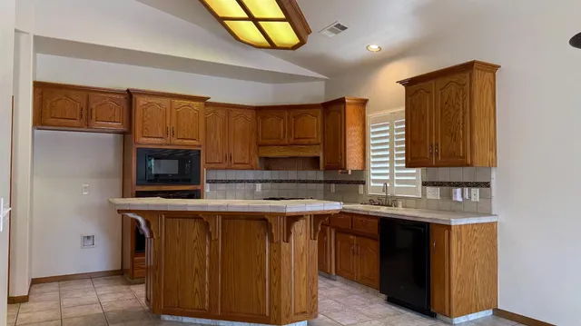 a kitchen with stainless steel appliances granite countertop a sink a stove a refrigerator and a microwave
