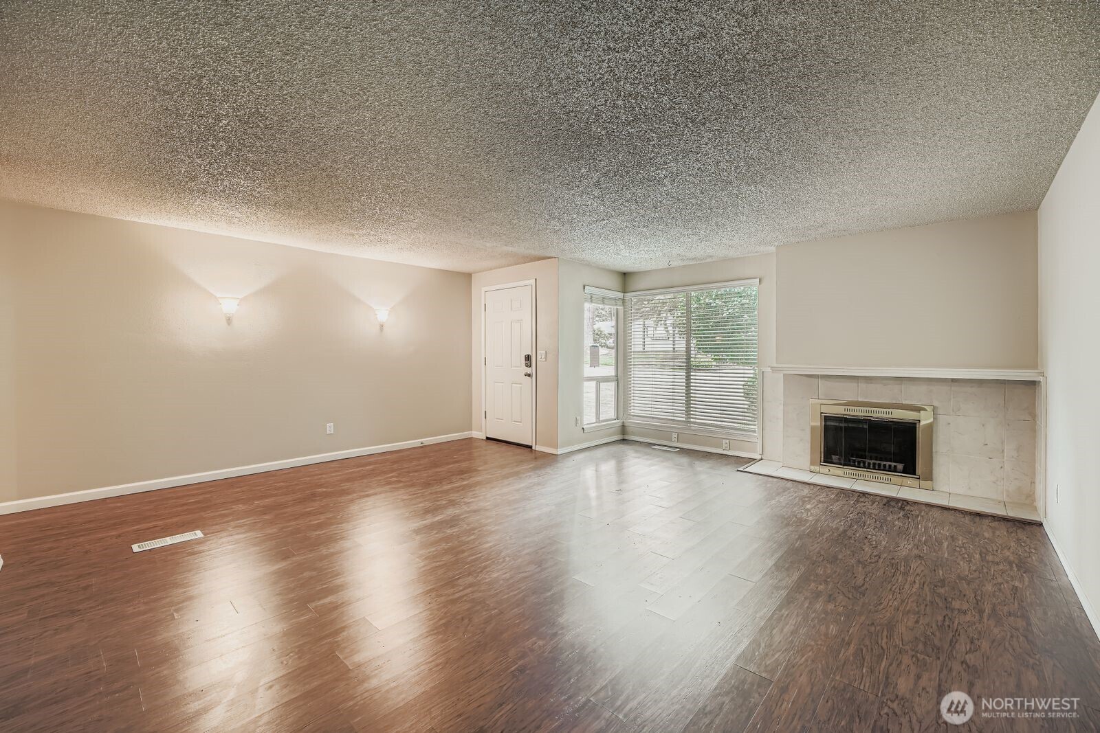 2738 Southwest 323rd Street Federal Way, WA 98023 - Photo 4 of 26 an empty room with wooden floor fireplace and windows