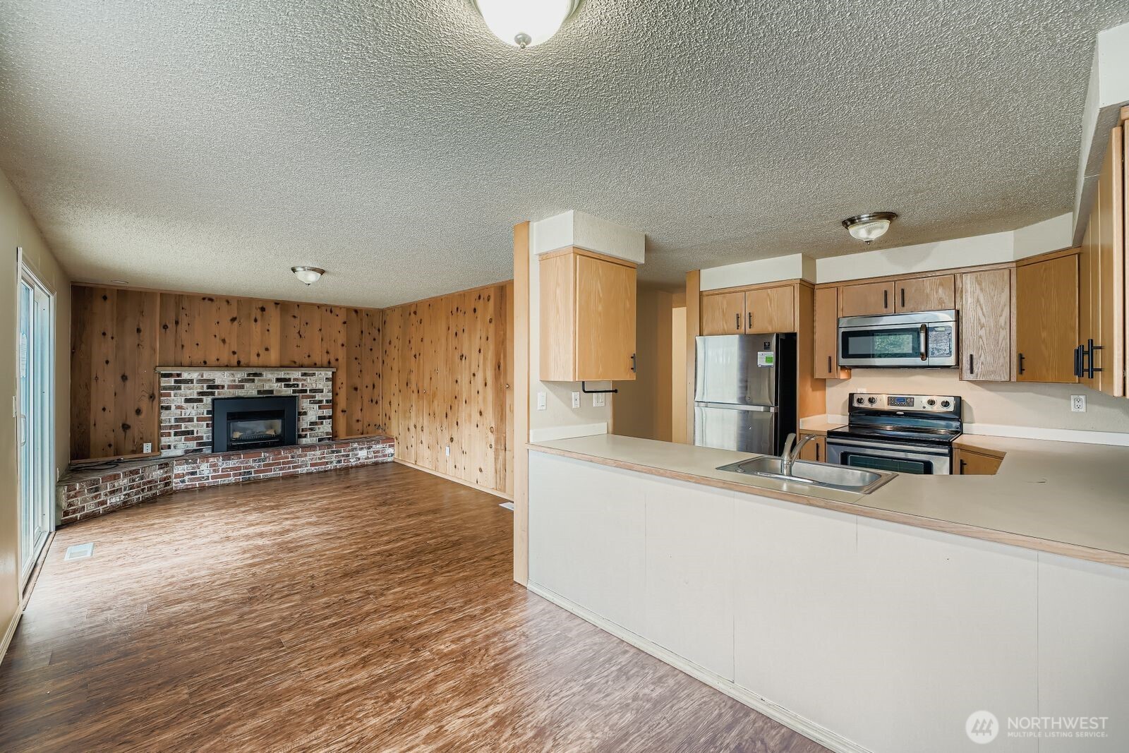 2738 Southwest 323rd Street Federal Way, WA 98023 - Photo 7 of 26 a large kitchen with a stove a refrigerator and a view of living room