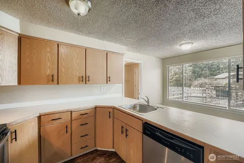 a kitchen with granite countertop a sink cabinets and window