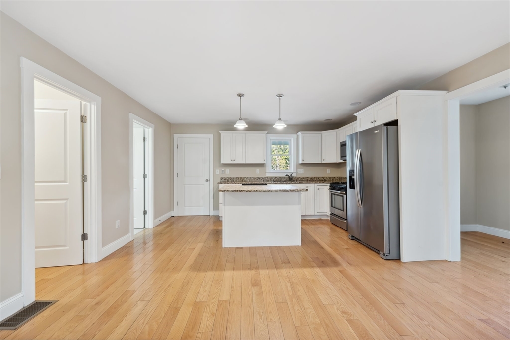 2 Pine Cone Lane East Freetown, MA 02717 - Photo 5 of 38 a large kitchen with a refrigerator a stove and white cabinets with wooden floor