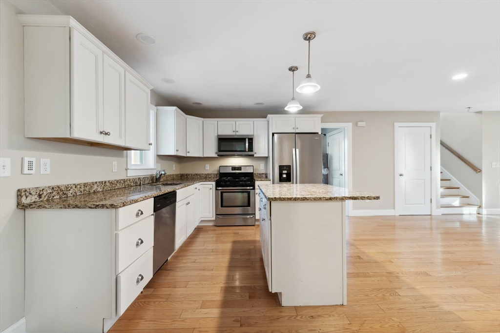 2 Pine Cone Lane East Freetown, MA 02717 - Photo 7 of 38 a kitchen with granite countertop a stove top oven a sink dishwasher and white cabinets with wooden floor