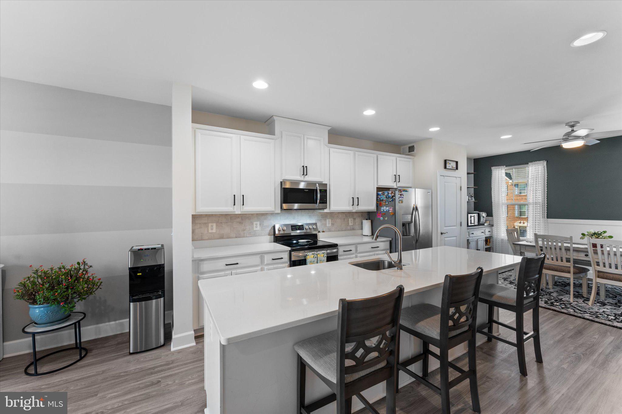 7075 Mongoose Trail Gainesville, VA 20155 - Photo 8 of 54 a kitchen with a dining table chairs stainless steel appliances and cabinets