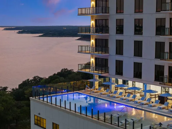 a view of swimming pool with outdoor seating and lake view