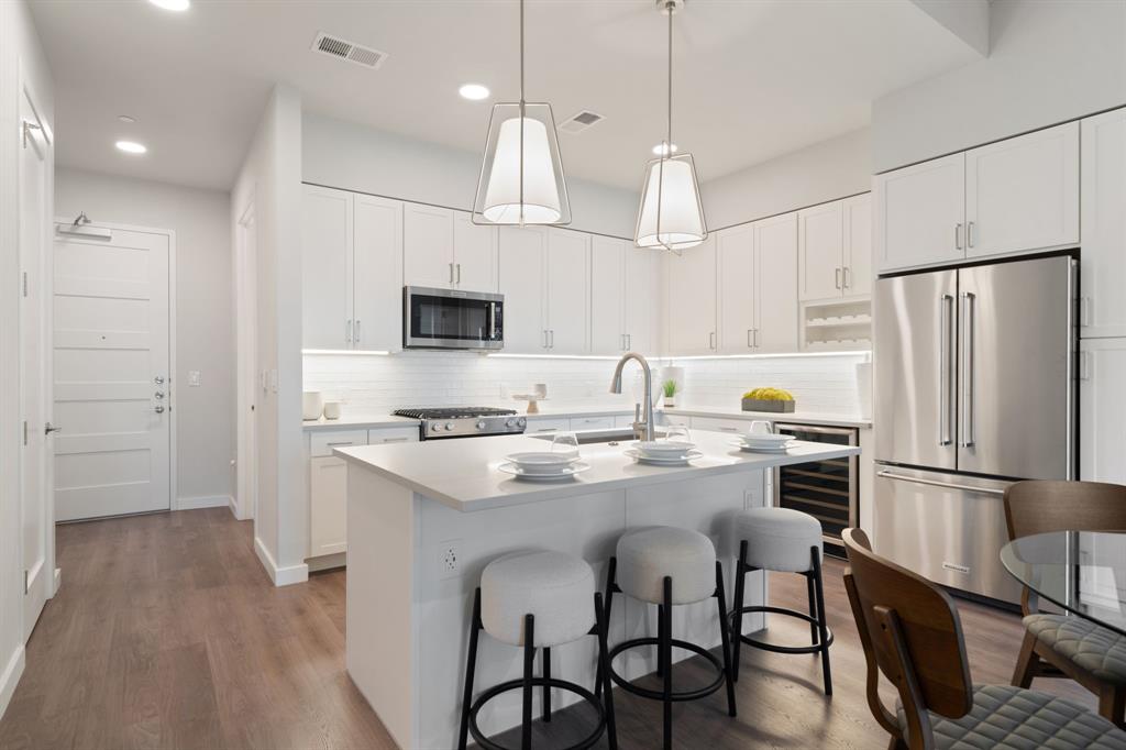 3111 Sunset Boulevard, Unit 1409 Flower Mound, TX 75022 - Photo 5 of 37 a kitchen with stainless steel appliances granite countertop a sink a stove a refrigerator cabinets a dining table and chairs