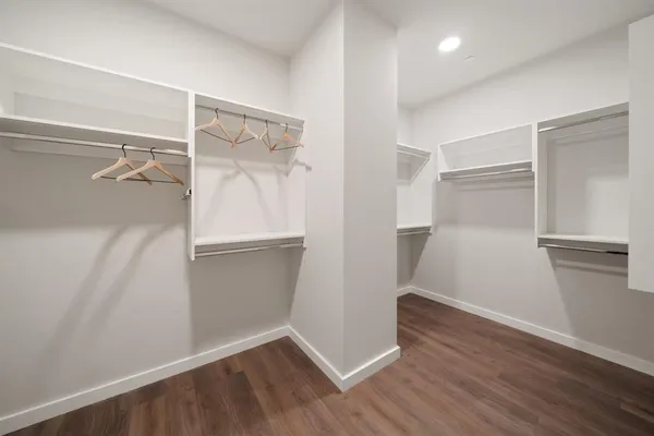 an empty walk in closet with wooden floor