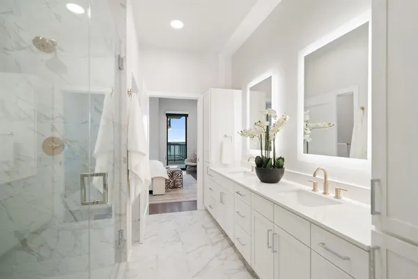 a bathroom with a double vanity sink mirror and shower