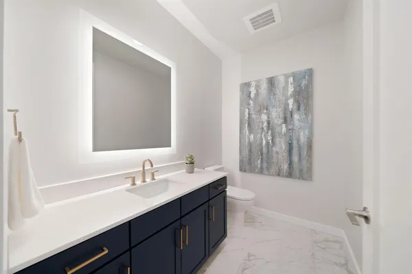 a bathroom with a double vanity sink toilet and a mirror