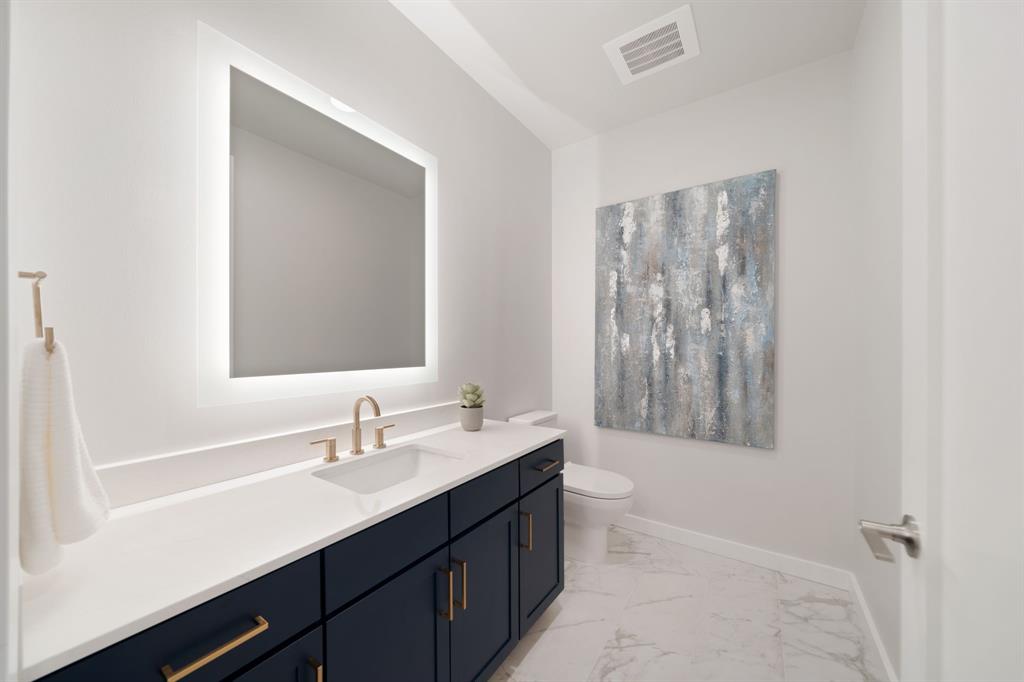 3111 Sunset Boulevard, Unit 1409 Flower Mound, TX 75022 - Photo 9 of 37 a bathroom with a double vanity sink toilet and a mirror