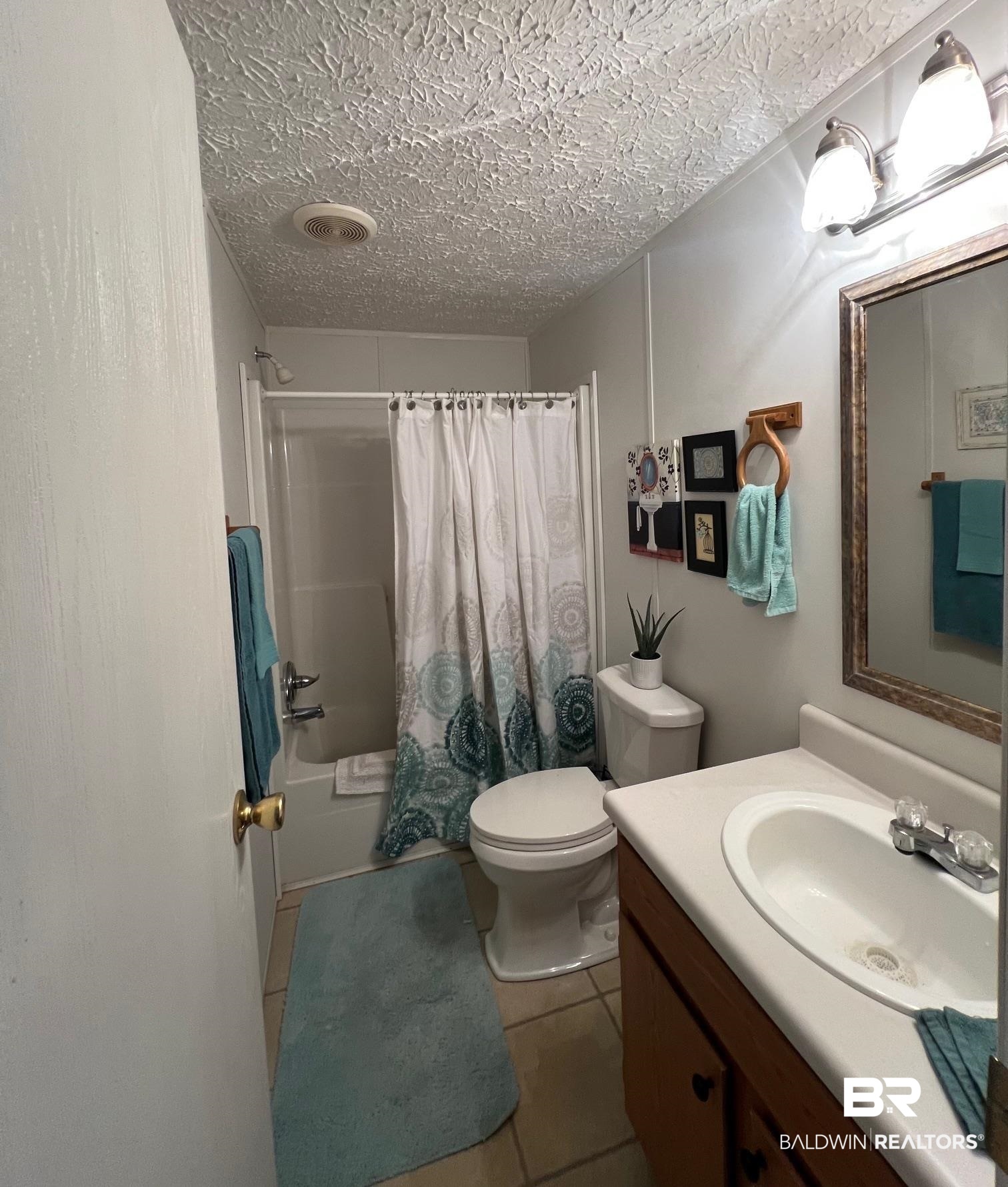 1936 Ridgewood Drive Lillian, AL 36549 - Photo 8 of 30 Bathroom featuring vanity, tile patterned floors, a textured ceiling, toilet, and visible vents