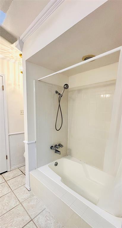 4019 Rive Lane Addison, TX 75001 - Photo 19 of 37 White tile-surround soaking tub with wall-mounted shower fixture and tiled flooring