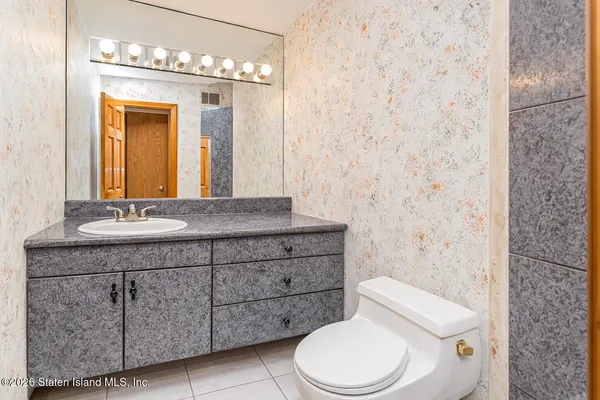 a bathroom with a granite countertop toilet sink and mirror