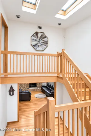 a view of a hallway with wooden floor and windows