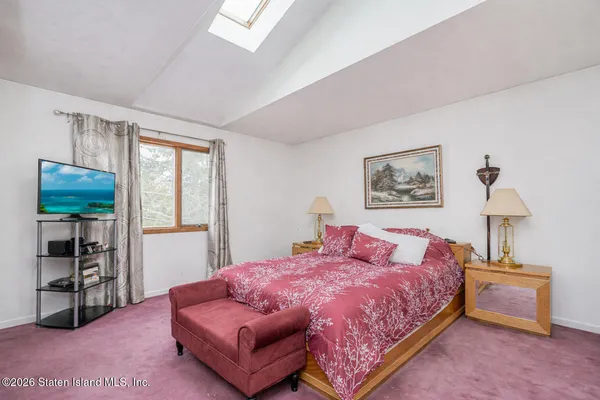 a bedroom with a bed a mirror and lamp on table