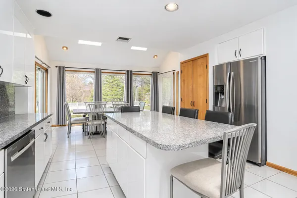 a kitchen with stainless steel appliances granite countertop table chairs and a refrigerator