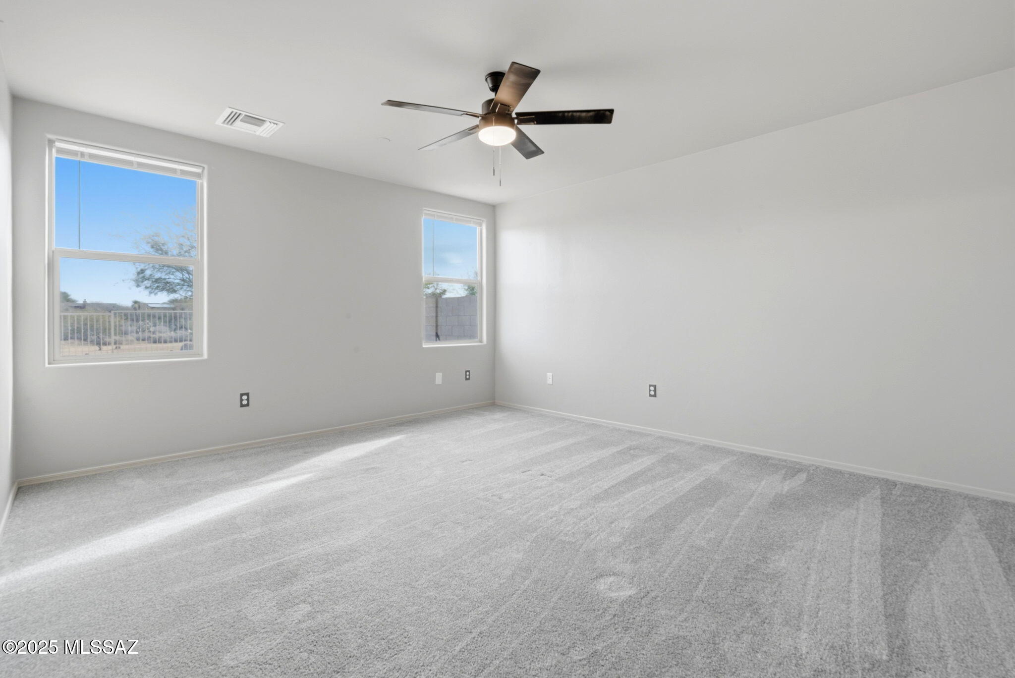 1458 North Wentworth Road Vail, AZ 85641 - Photo 17 of 44 a view of an empty room with a ceiling fan and window