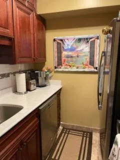 a view of a refrigerator a sink and cabinets