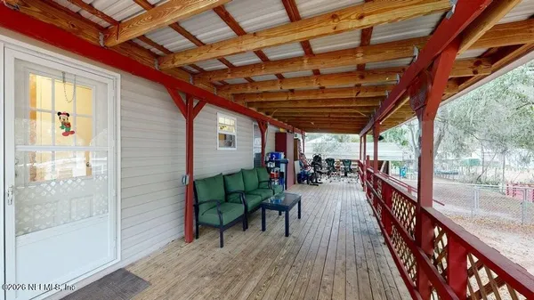 a view of a porch with wooden floor and outdoor seating