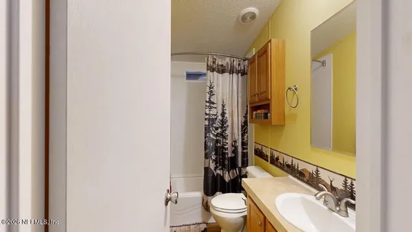 a bathroom with a sink a toilet a mirror and shower