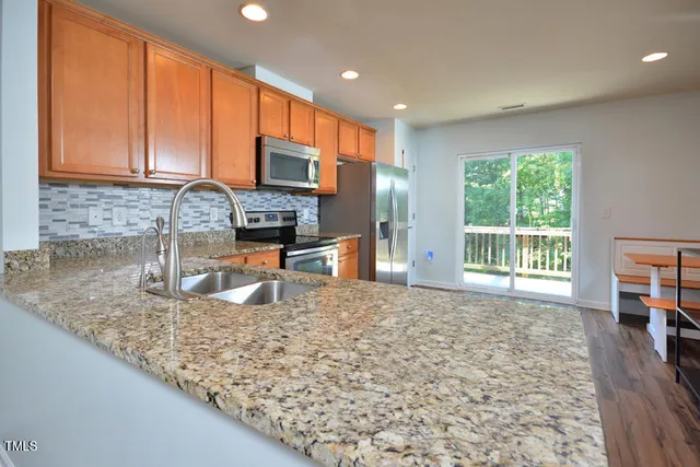 a kitchen with kitchen island granite countertop a sink and a counter top space