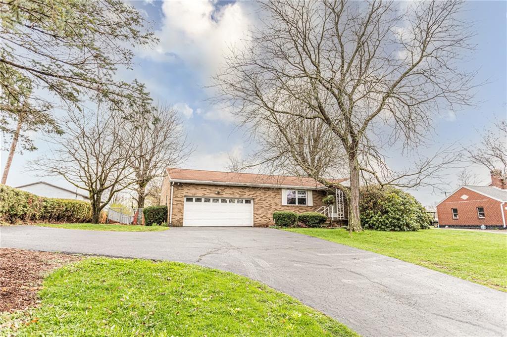 673 Vanderbilt Road Connellsville, PA 15425 - Photo 1 of 28 a front view of a house with a yard and garage