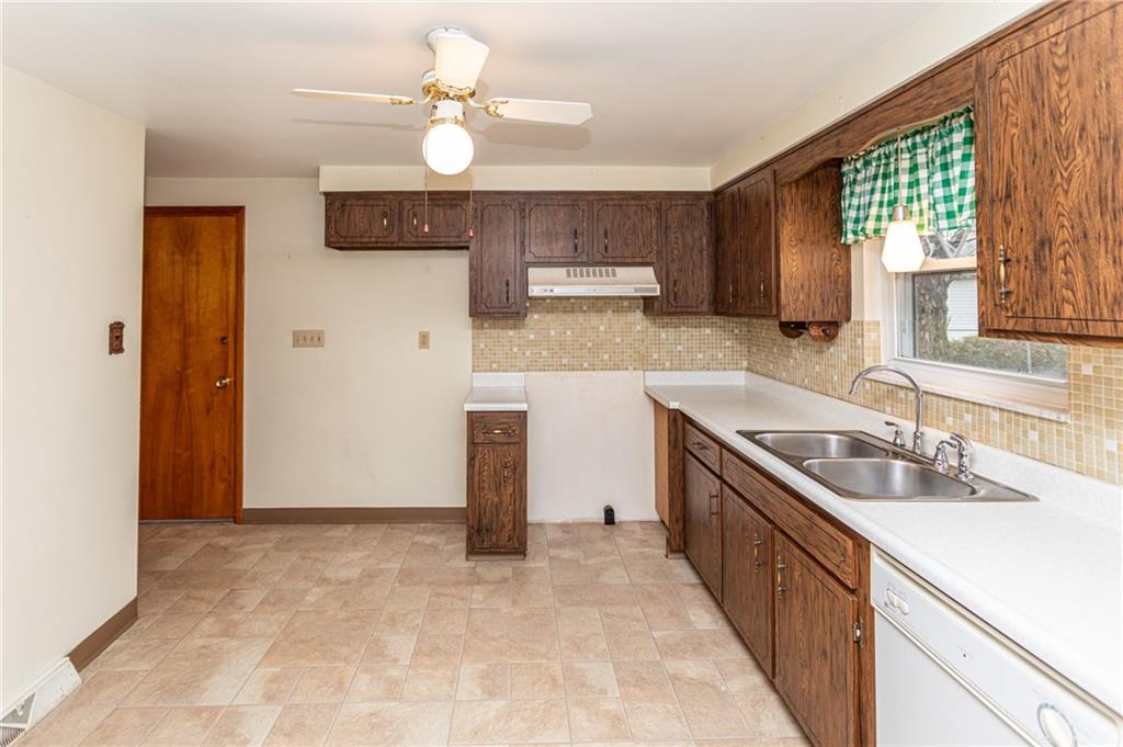 673 Vanderbilt Road Connellsville, PA 15425 - Photo 13 of 28 a kitchen with kitchen island granite countertop a sink appliances cabinets and a counter top space