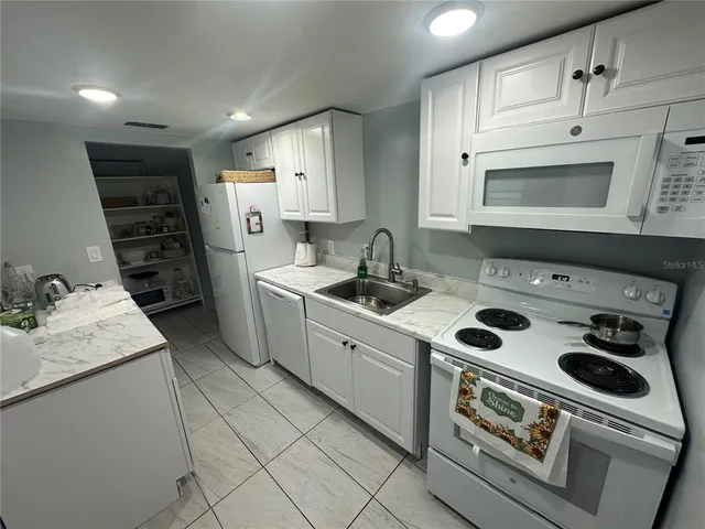 a kitchen with appliances a sink and cabinets