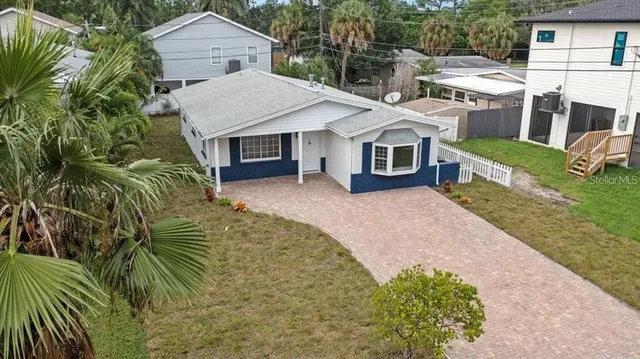 a front view of a house with a garden and trees
