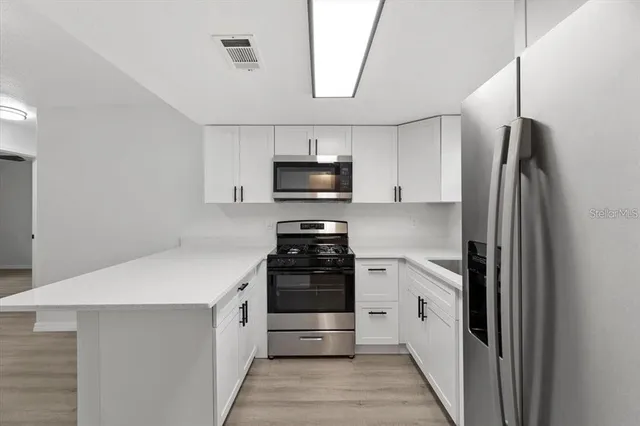 a kitchen with stainless steel appliances a stove microwave and a refrigerator
