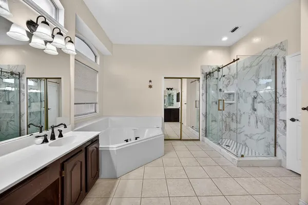 a bathroom with a double vanity sink mirror and shower