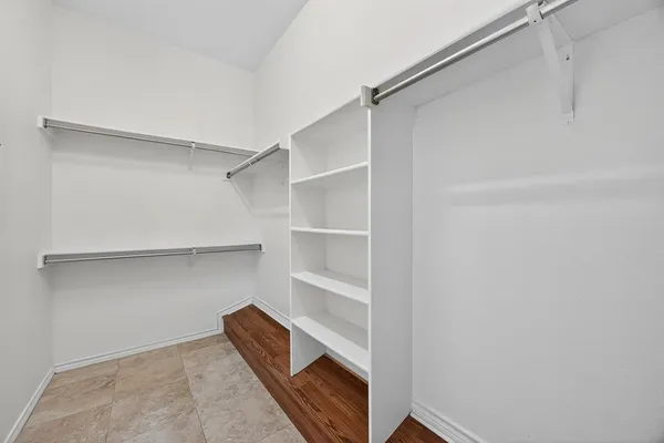 a view of walk in closet with empty racks