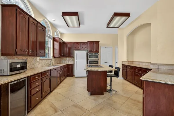 a kitchen with stainless steel appliances granite countertop wooden cabinets a stove top oven a sink and dishwasher