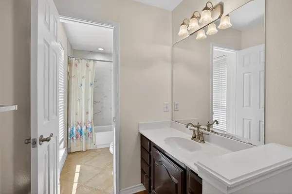 a bathroom with a sink a light fixture and a mirror