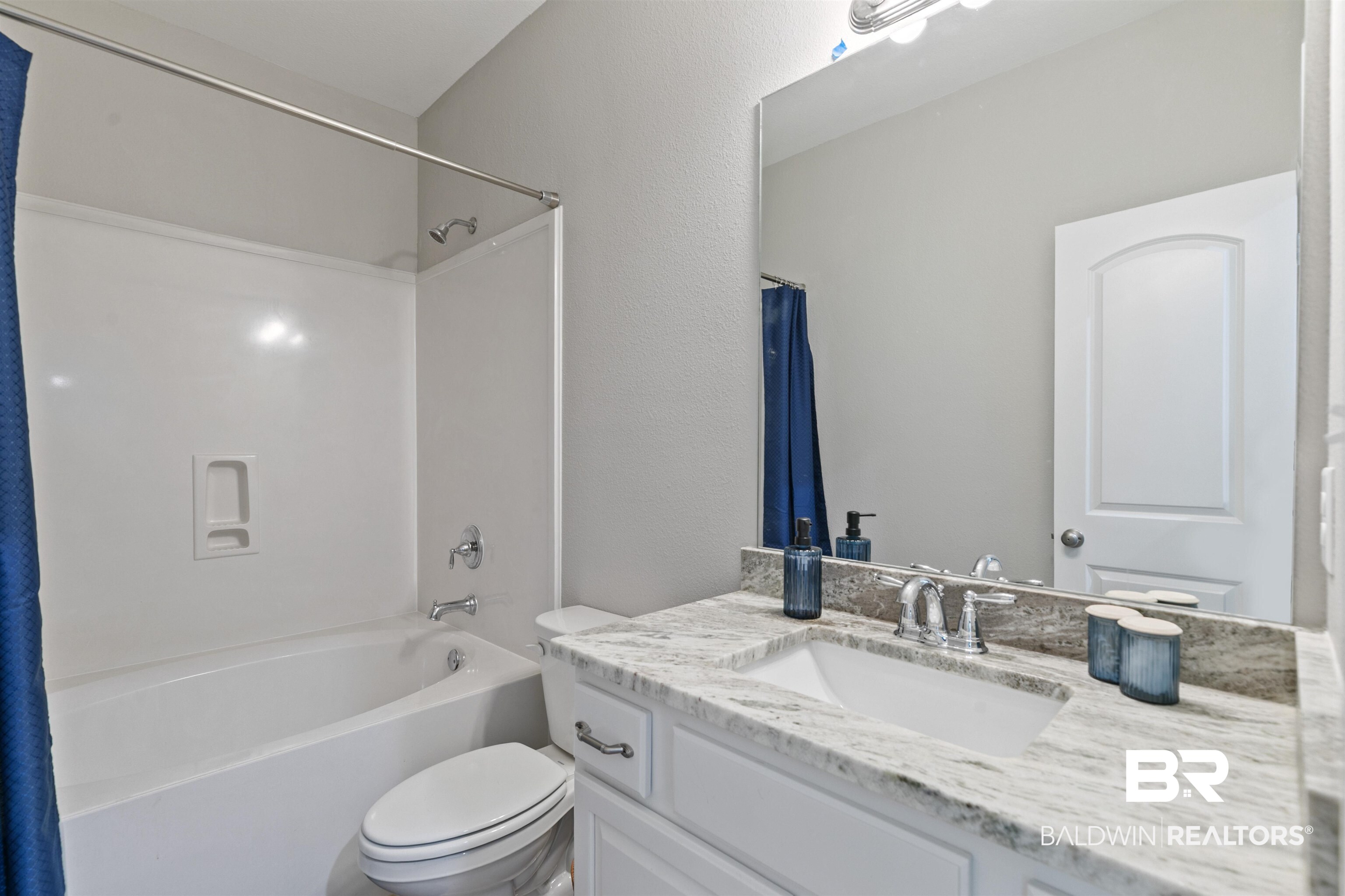 8552 March Road Irvington, AL 36544 - Photo 21 of 28 Bathroom featuring a white vanity with paneling, a stone-finish countertop, and a rectangular undermount sink