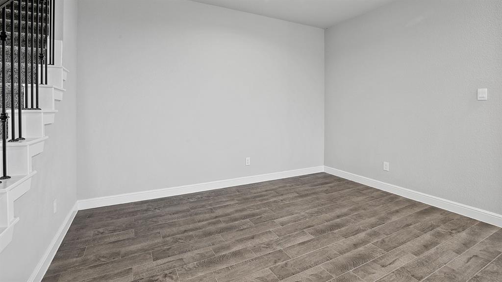 215 Windmill Drive Rhome, TX 76078 - Photo 8 of 37 a view of an empty room with wooden floor and a window