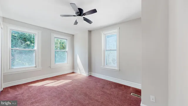 an empty room with windows and closet