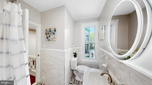 a bathroom with a sink a toilet and a mirror