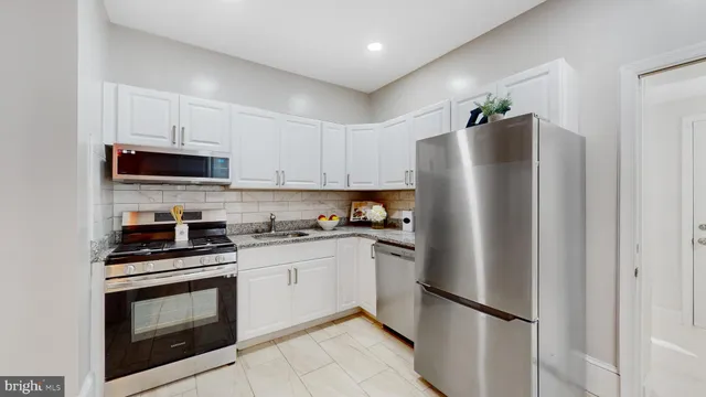 a kitchen with stainless steel appliances a refrigerator stove and microwave