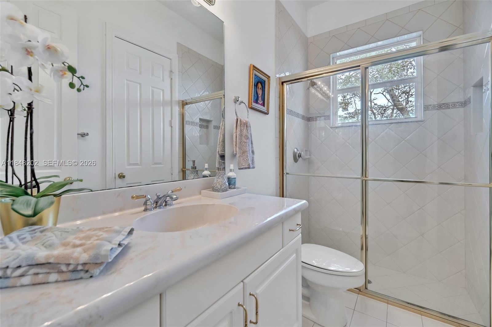 14211 Southwest 63rd Street Southwest Ranches, FL 33330 - Photo 26 of 81 a bathroom with a granite countertop sink a toilet a mirror and shower