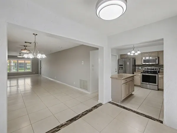 a view of a kitchen with a sink and chandelier