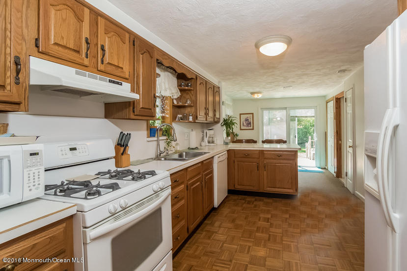 737 Wall Road Spring Lake Heights, NJ 07762 - Photo 13 of 26 a kitchen with a stove top oven a sink and a refrigerator