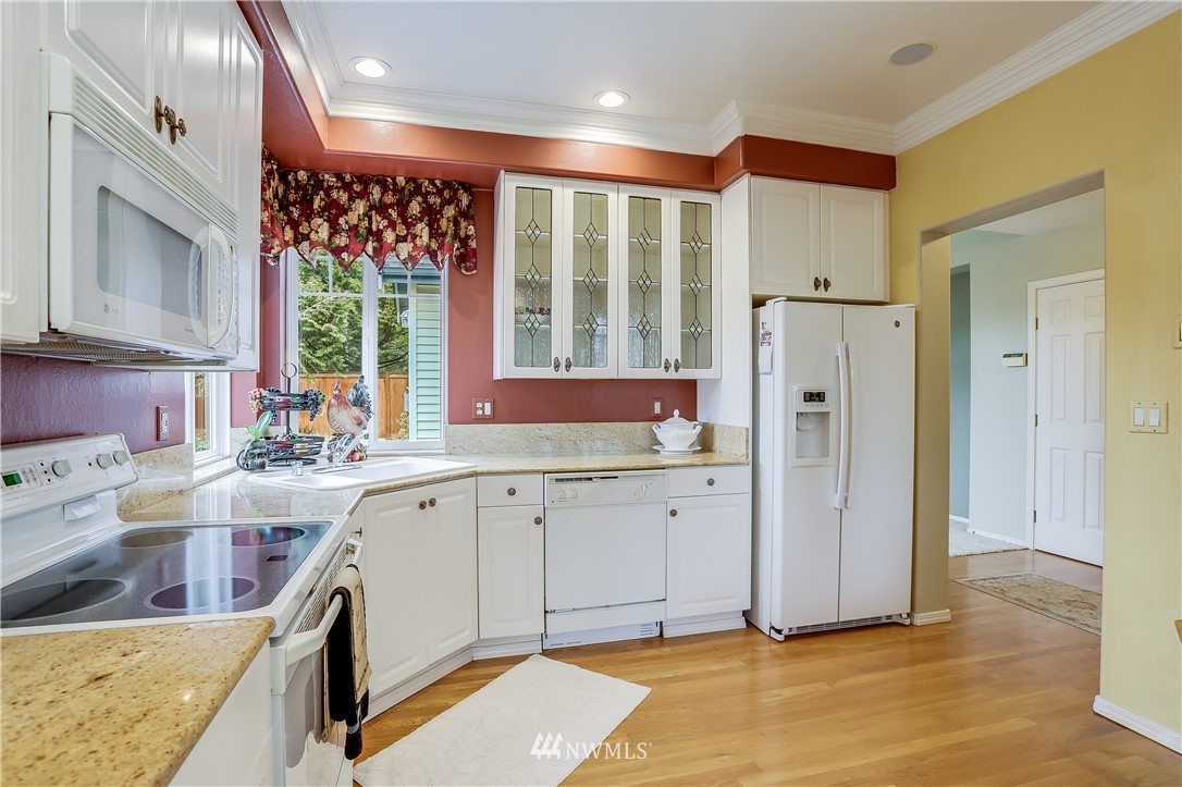 672 Chelan Place Northeast Renton, WA 98059 - Photo 11 of 24 a kitchen with stainless steel appliances granite countertop a refrigerator sink and cabinets