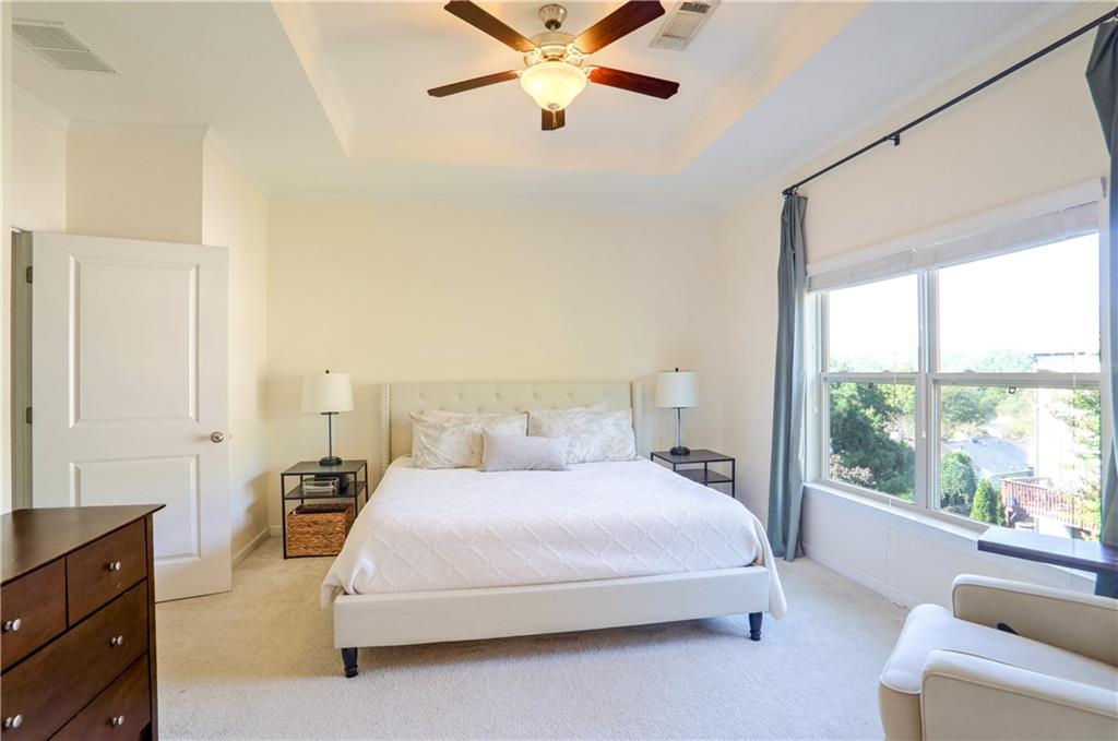 3216 Creole Lane Decatur, GA 30032 - Photo 11 of 25 a bedroom with a large bed and a chandelier fan